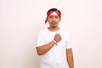 Naklejka premium Asian man standing with respect gesture. Indonesian independence day concept. Isolated on white