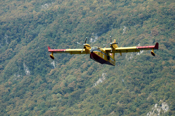 Fototapeta na wymiar Canadair in fase di ricarica presso il lago di Cavazzo, Udine, Italia