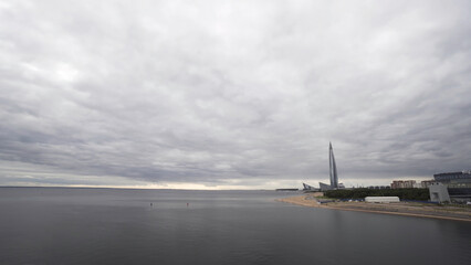 Fototapeta na wymiar Russia, St. Petersburg, panoramic view of skyscraper Lakhta center at day time. Action. Highest skyscraper in Europe and the heavy cloudy sky above Neva river.