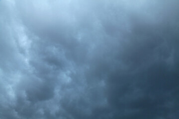 Atmosphere and formation of rain. Low hanging clouds with rain on the background of a gray sky. Rain clouds, texture, background. Gray sky and bad weather in summer. Climate change