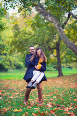 Naklejka na ściany i meble Young couple walking in the park in autumn