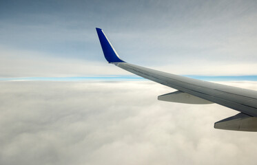 Airplane wing on a cloudy sky