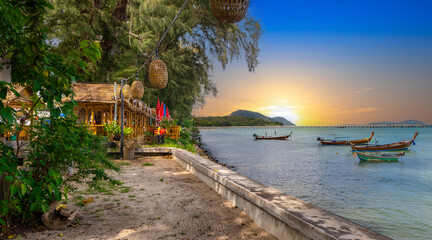 Colourful Skies Sunset over Rawai Beach in Phuket island Thailand. Lovely turquoise blue waters,...
