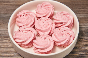 beautiful pink homemade marshmallow in a white round plate on a wooden background