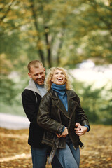 Romantic couple standing in a forest, hugging and posing for a photo