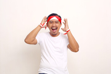 Fototapeta premium Wow and amazed expression of asian man. Indonesian independence day concept. Isolated on white