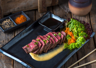 Grilled SUKIYAKI STEAK served in a dish isolated on wooden background side view of steak