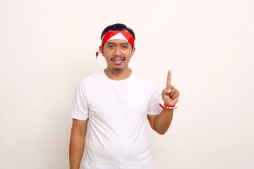 Naklejka premium Indonesian man standing while showing one finger. Independence day gesture. Isolated on white