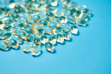 transparent capsules with omega on a blue background. dietary supplements, vitamins