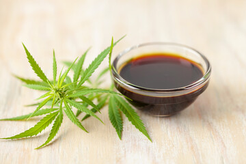 Oil and  hemp leaves and on a wooden background. Cannabis oil in a bottle. Natural eco product