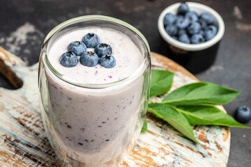 blueberry yoghurt shake in glass jar on a dark background, place for text, top view
