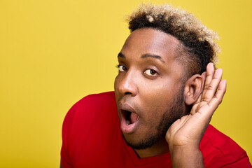 Close-up of a attentive black guy listening overhearing eavesdropping with his ear secret...