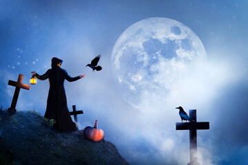 Fototapeta na wymiar The sorcerer and birds in the cemetery at the moon. Mystical image. Halloween.