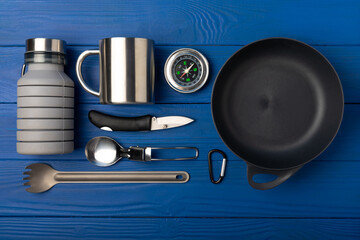 Set of tourist equipment on a blue wooden background.EDC set.flat lay.Camping...