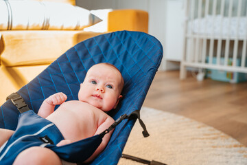 Caucasian baby lies on a chaise longue in kid's room