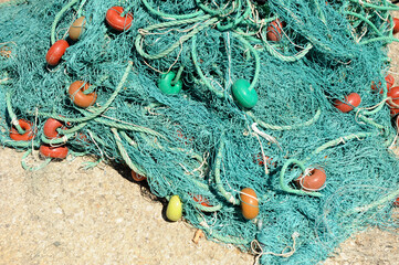 Redes de pesca y flotadores de plástico apiladas en el puerto pesquero de Rota, costa de Cádiz,...