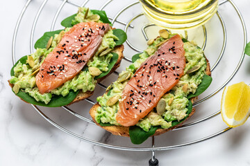 toast with avocadoo, salmon and spinach, nuts, sunflower seeds. Healthy, clean eating. Vegan or gluten free diet. top view, copy space