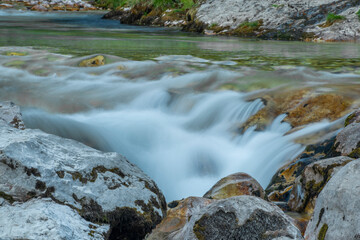 Naklejka na ściany i meble Light blue water in Soca river in summer hot evening in Slovenia