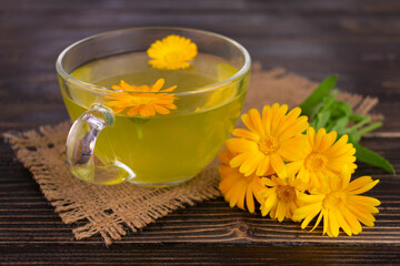 Medicinal tea from calendula flowers in a transparent cup.Close-up.
