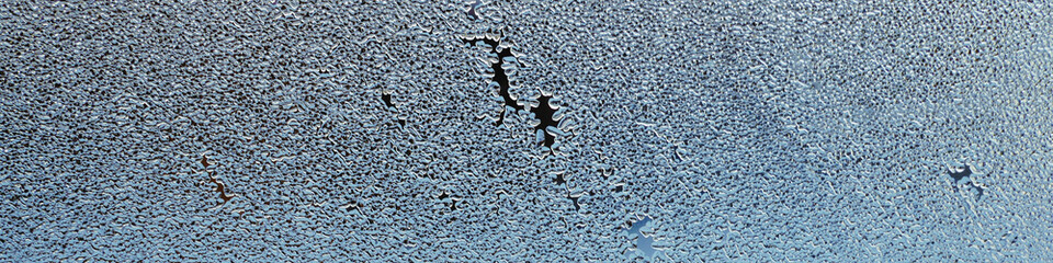 Winter light blue banner or header. A small pattern of ice crystals or frost on a window pane. Abstract Christmas or New Year theme headline. Macro