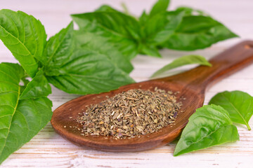 Dry basil in a wooden spoon. Natural spices.
