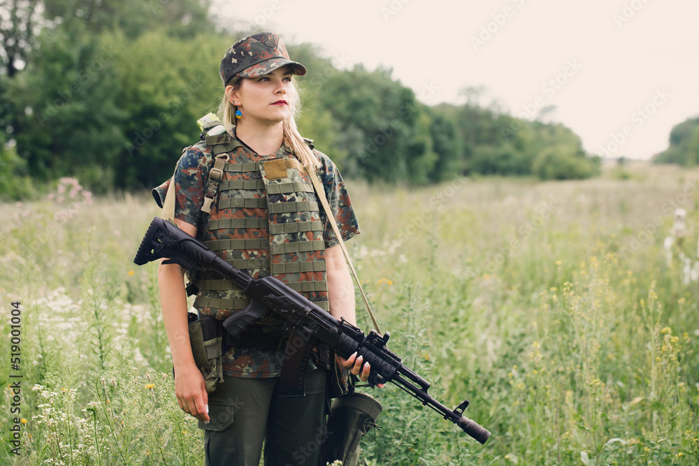 Wall mural Ukrainian female military servicewoman with a machine gun