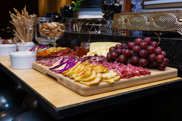 Plate of cold cuts served at the table, with fruit decoration
