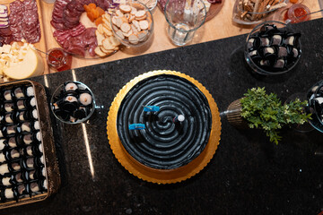 Table with cold cuts and birthday cake.