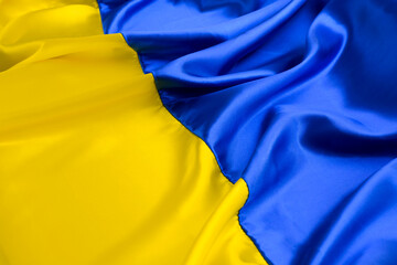 Fabric wave flag of Ukraine, UA. Blue and yellow bright colors. Curved texture background