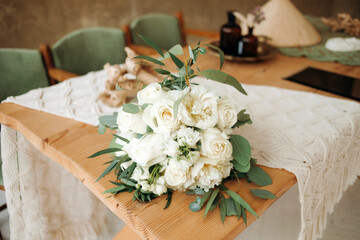 Beautiful white-green bouquet of the bride on a wooden table