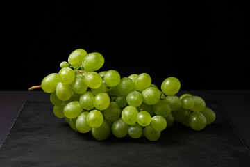 White grapes on a black background. Grape sort. Delicious and healthy fruit