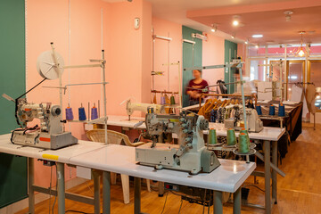 Sewing workshop with a raw of tables and machines to work