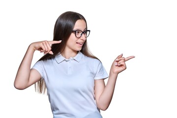 Teenage girl pointing fingers to the side at space for text, on white isolated background