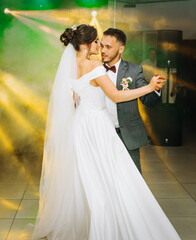 The first wedding dance of the newlyweds..Romantic atmosphere. Light floodlights in the hall.