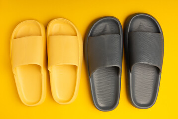 A pair of stylish rubber slippers on a yellow background.Changeable shoes.Beach shoes.Copy space. Place for text.