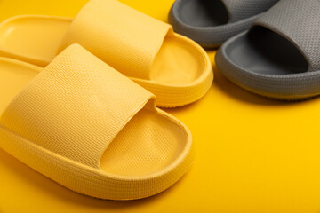 A pair of stylish rubber slippers on a yellow background.Changeable shoes.Beach shoes.Copy space. Place for text.