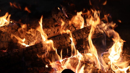 Campfire burning with a lot of ember and heat, with strong colors with a sensation of incandescent heat.