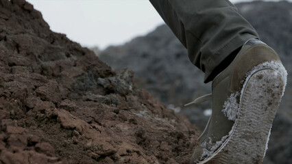Close up of hiking boots and legs climbing up rocky trail. Footage. Close up climber legs make a...