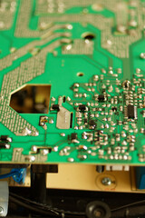 Close up of an electronic component on a green circuit board with deep bokeh
