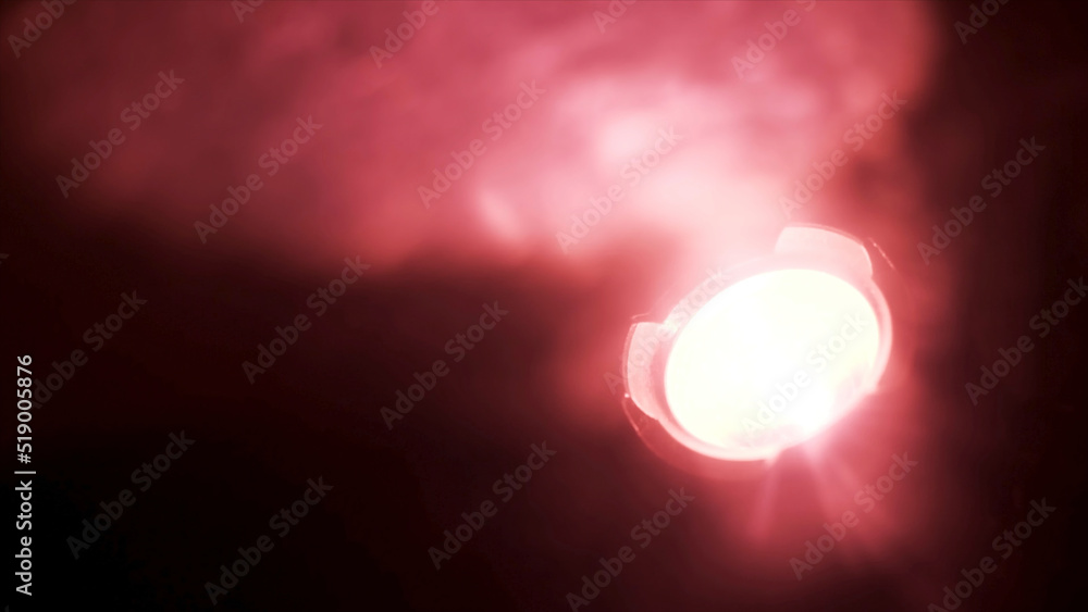 Poster close up of red spotlight blinking in complete darkness. action. red soffit shimmering in the dark r