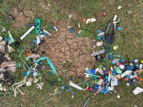 close-up of plastic garbage and plastic pollution in the middle of the forest which is an environmental disaster, pollution and danger