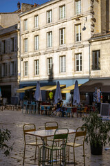 An empty outdoor area of a traditional french restaurant or cafe in a historic downtown. Tables and chairs without visitors.  Business in HoReCa.