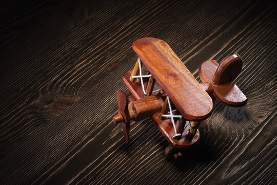 Wood toy plane on rustic wooden table.