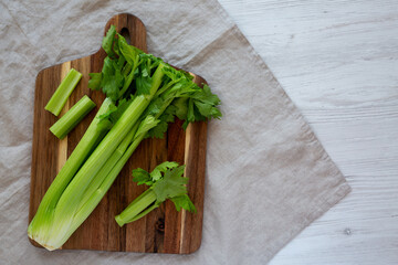 Raw Organic Celery on a wooden board, top view. Flat lay, overhead, from above. Space for text.