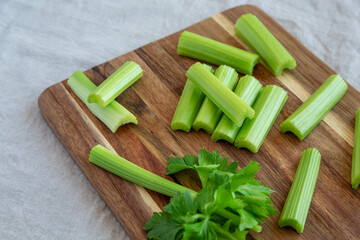 Raw Organic Celery on a wooden board, side view. Close-up.