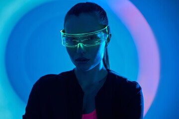 Confident young woman in futuristic glasses looking at camera