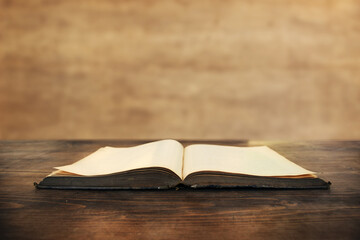 Old open book on wood desk board