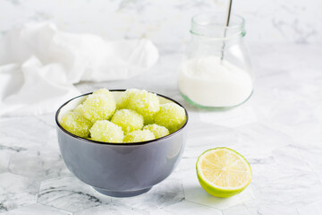 Sour candy grapes in a bowl and cooking ingredients on the table. Social media candy trend.