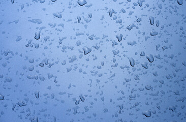 Raindrops on the metallic surface of the car in metallic color. After the rain. Background for text with drops.