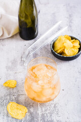 Beer slush in a glass and chips in a bowl on the table. Trendy summer drink. Vertical view